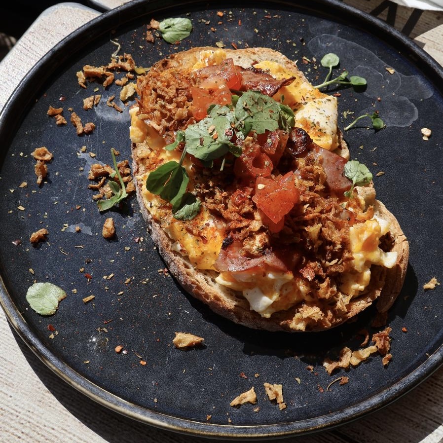 Mafra bread, homemade scrambled eggs, bacon, cherry tomato, spices, micro-herbs